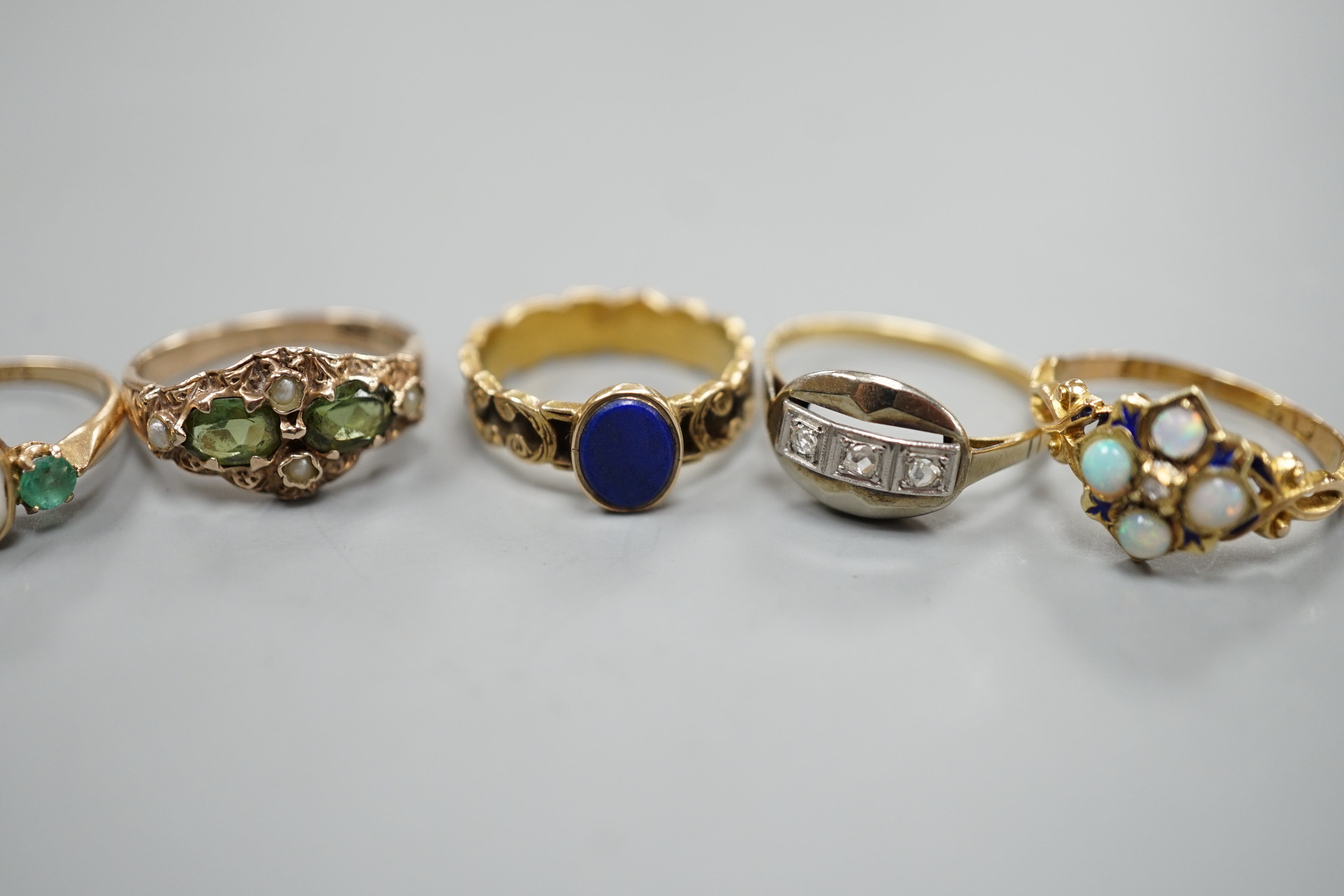 Five assorted early 20th century and later gem set rings, including 15ct white opal and enamel size O, gross weight 2.6 grams, a 585 emerald and white stone ring, gross 2 grams and three others including 9ct gold, gross